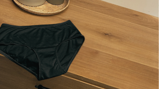 black cotton brief on a wood dresser
