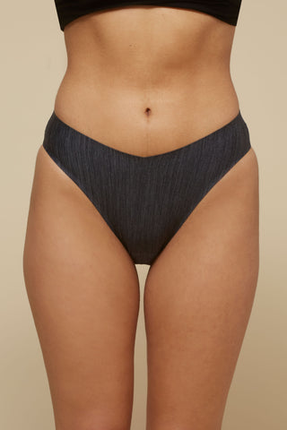 Front view image of model wearing Netherlin's black seamless french cut brief, made of aerated, quick-drying fabric and embedded with mineral fibers to inhibit odor and bacteria.